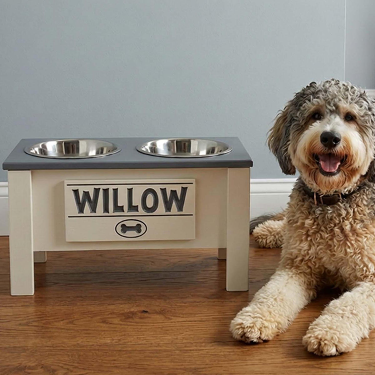 White elevated dog feeder with two steel bowls beside a curly coated dog