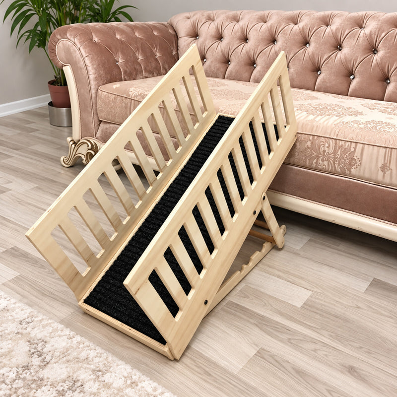Natural wood adjustable dog ramp with removable rails and black carpet beside a sofa