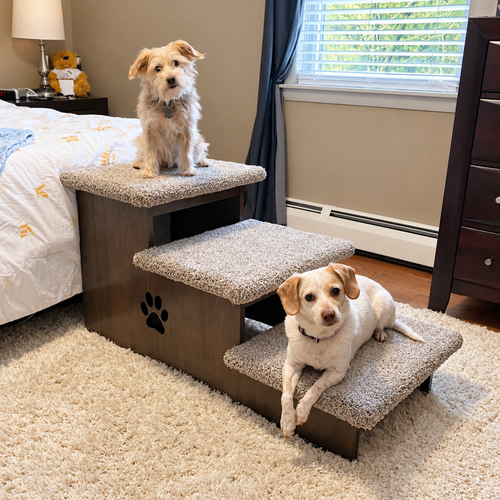 Extra deep wooden dog stairs beside a bed with two dogs